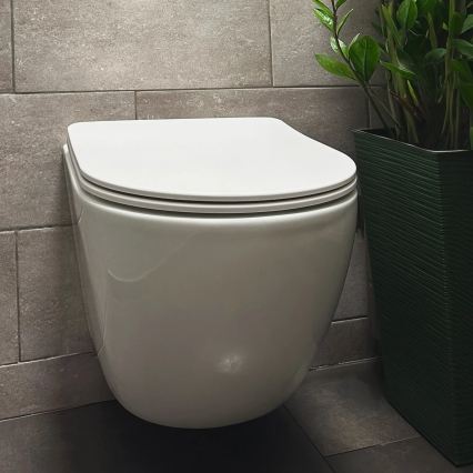 REA-C1259 - Viseča WC školjka z sedežno desko CARLO MINI TORNADO brez obroča keramika/sijajna bela